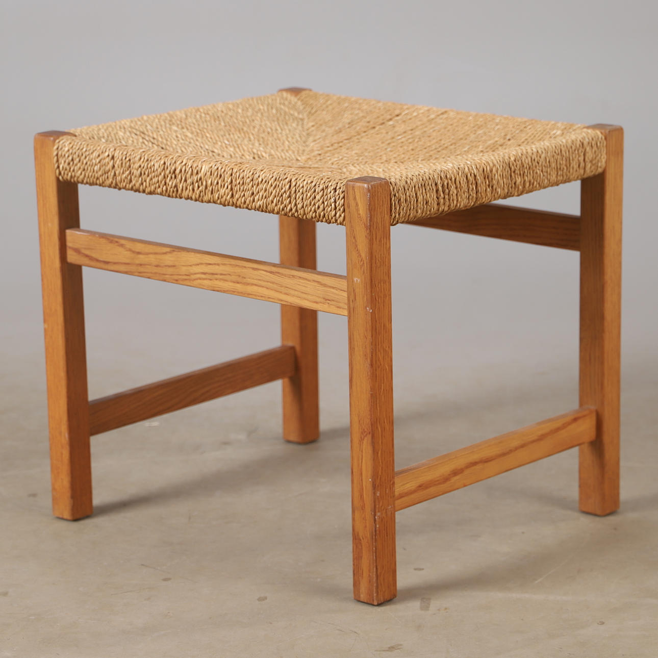 A mid 20th century oak and string stool.