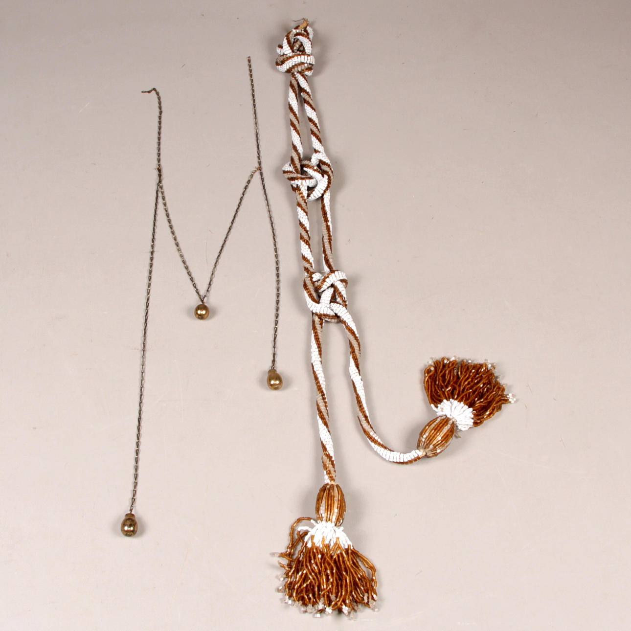 SPJÄLLSNÖREN, 2 st. Pärlor samt mässing, 1800/1900-tal.