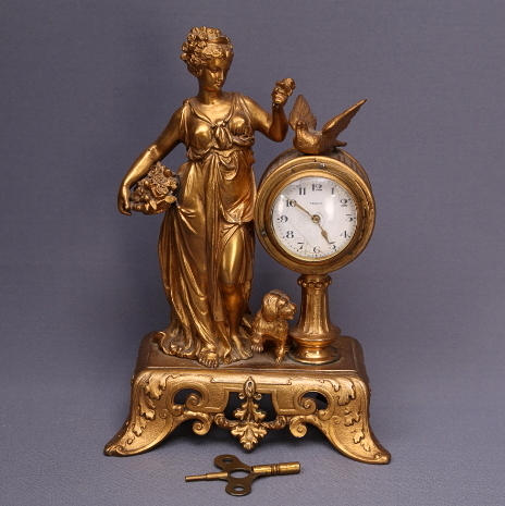 BORDSUR, förgylld metall, 18-/1900-tal, kvinna med duva och hund.