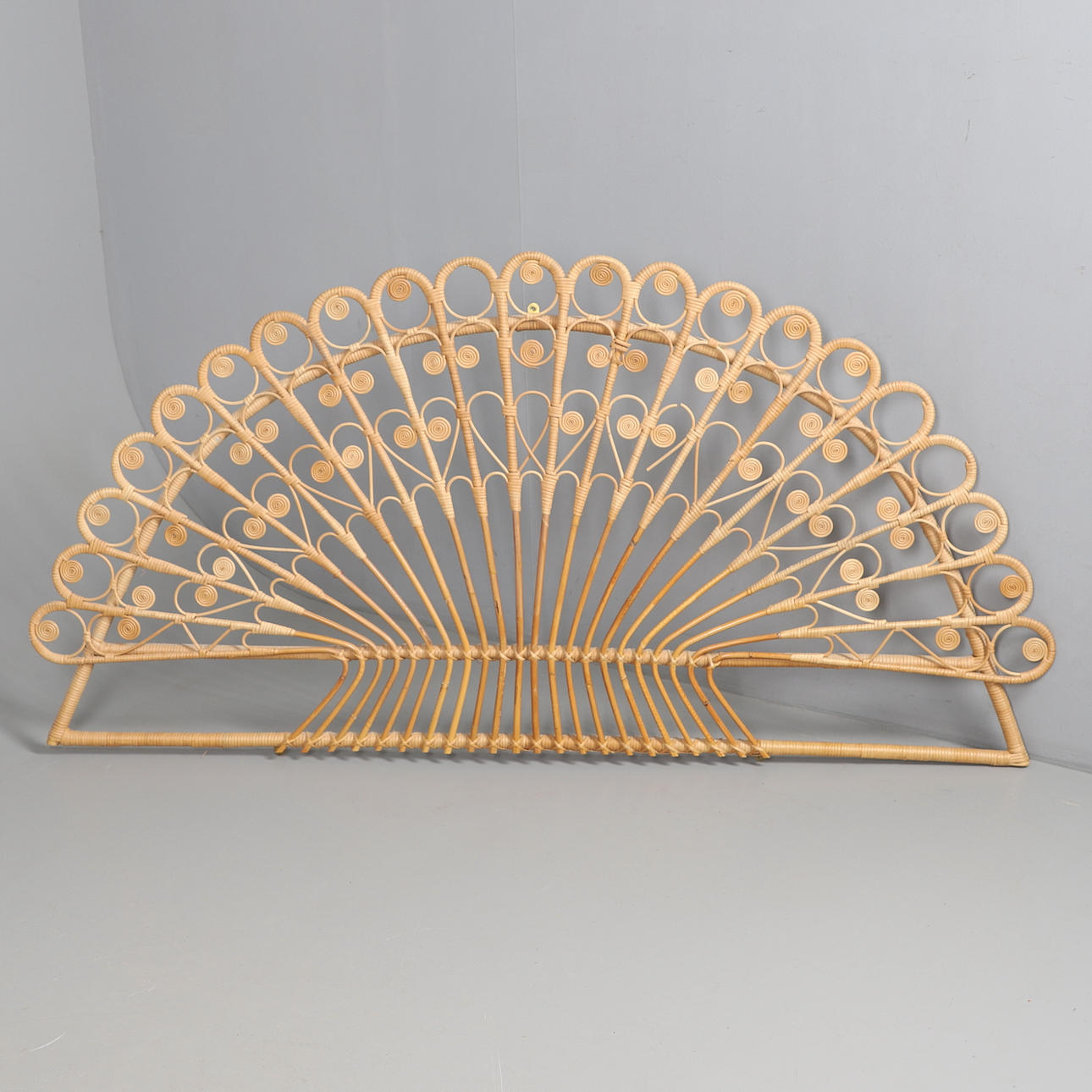 A 1970’s RATTAN PEACOCK HEADBOARD.