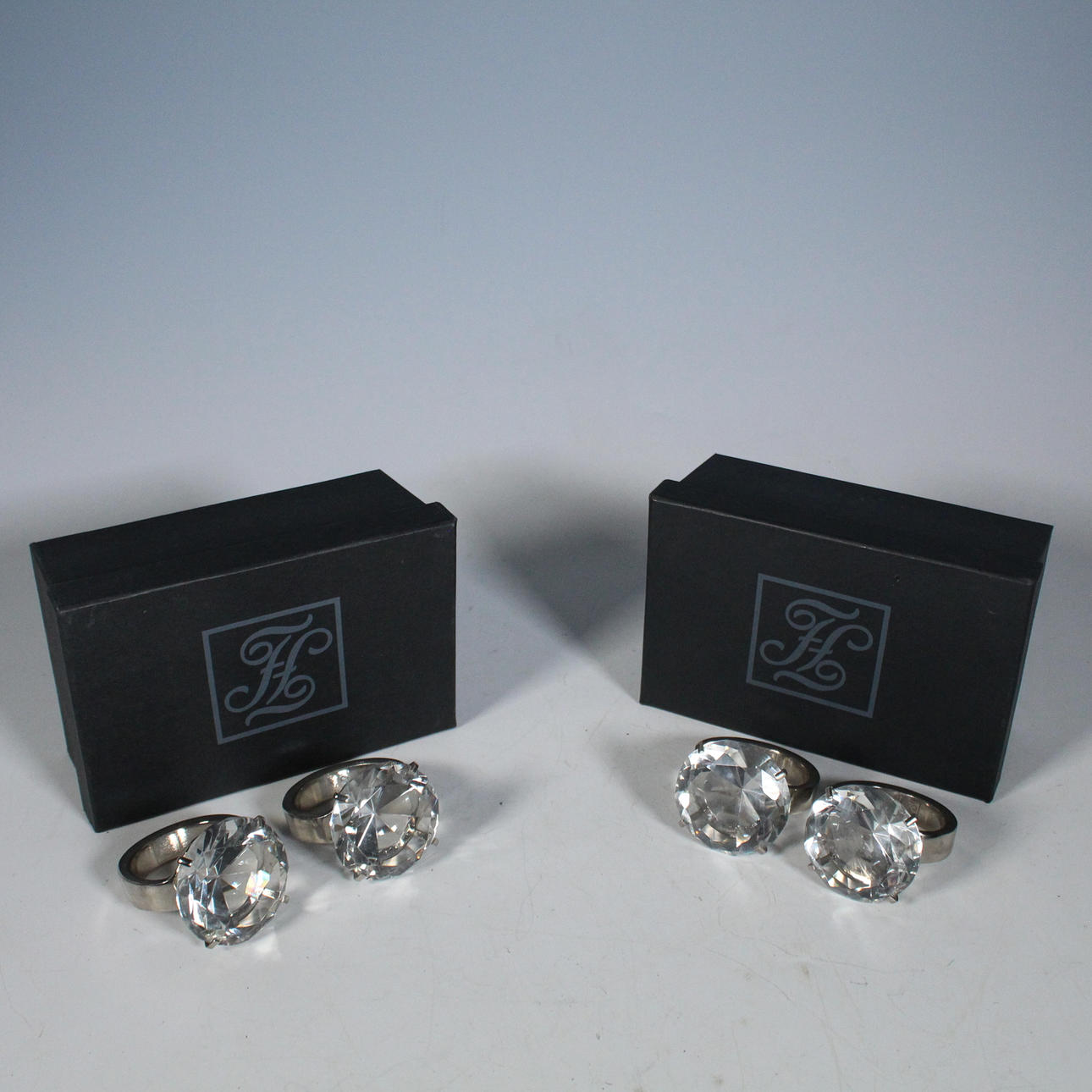 FINK. 4 Serviettenringe, Stahl, Glas.