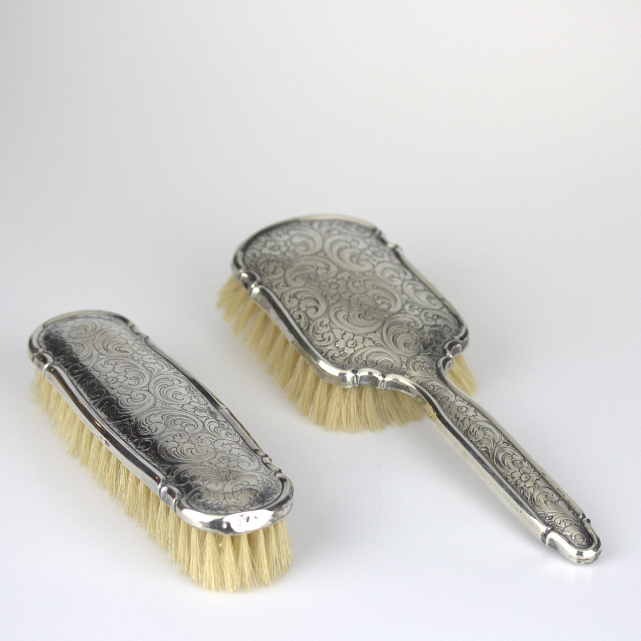 CLOTHES BRUSHES, 2 pcs. silver 830 in the shanks with embossed pattern.