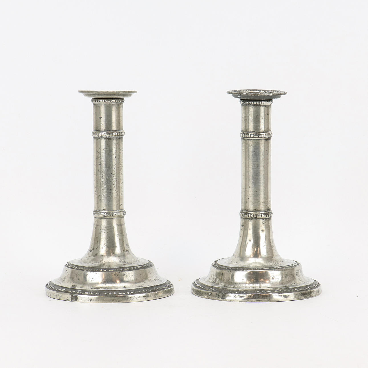 A pair of antique pewter candlesticks.