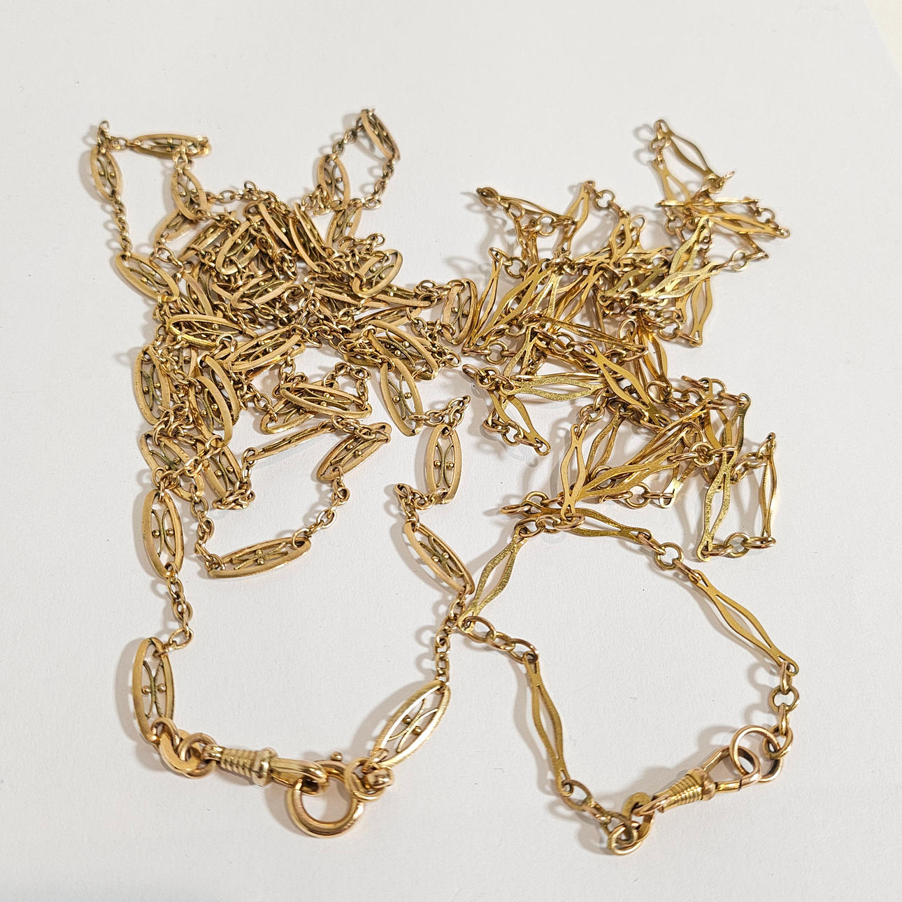 2 LEONTINAS EN METAL DORADO.