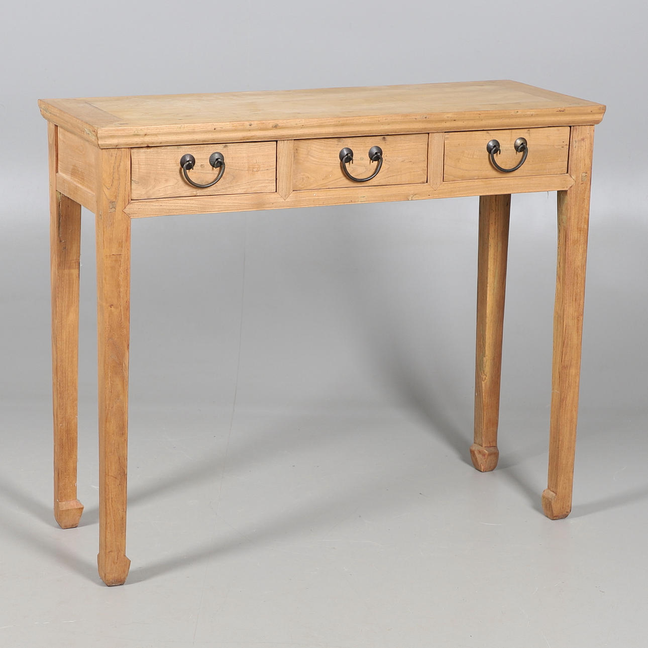 A CHINESE ELM THREE DRAWER SIDE TABLE.