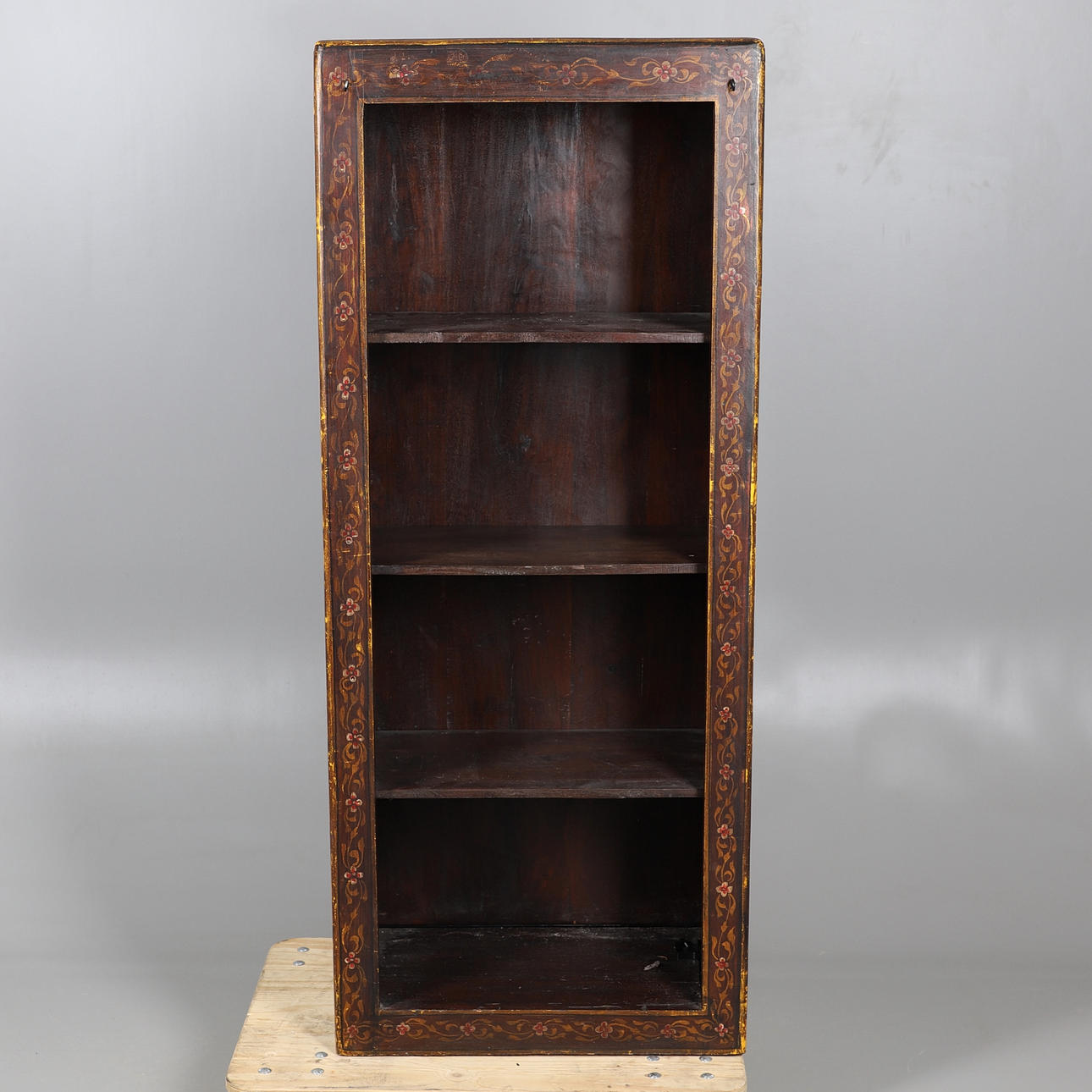 EN INDISK DEKORERAD ÖPPEN BOKHYLLA.