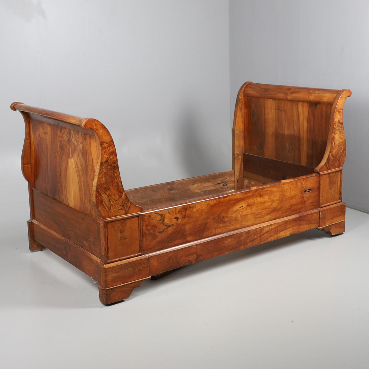 UNA CAMA TIPO TRINEO DE NOGAL FRANCÉS.