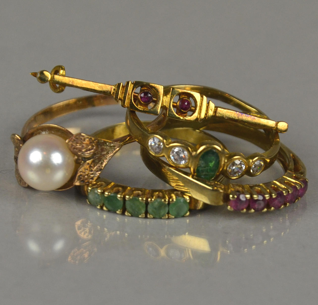 BUNT MASSA RINGAR OCH EN GULD BROSCH.