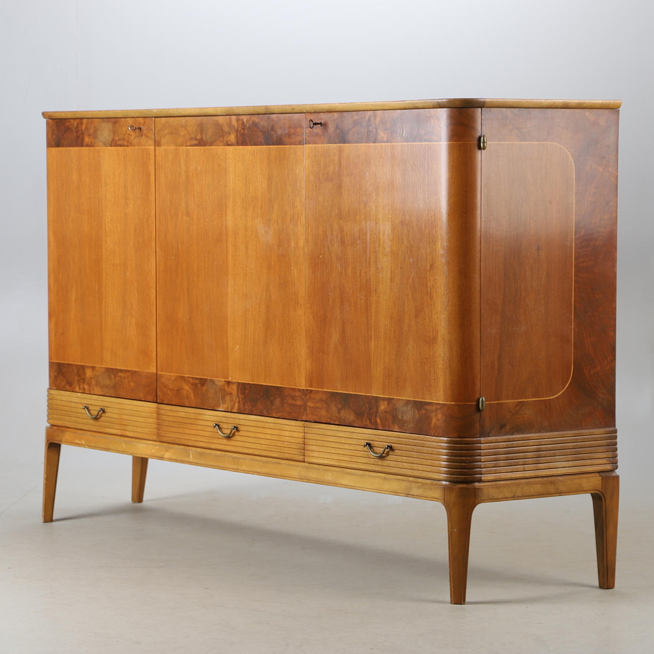 EIN SIDEBOARD AUS NUSSBAUM UND BUCHE, Oscar Edv. Ekelunds Snickerifabriks AB, Virserum, Mitte des 20. Jahrhunderts.