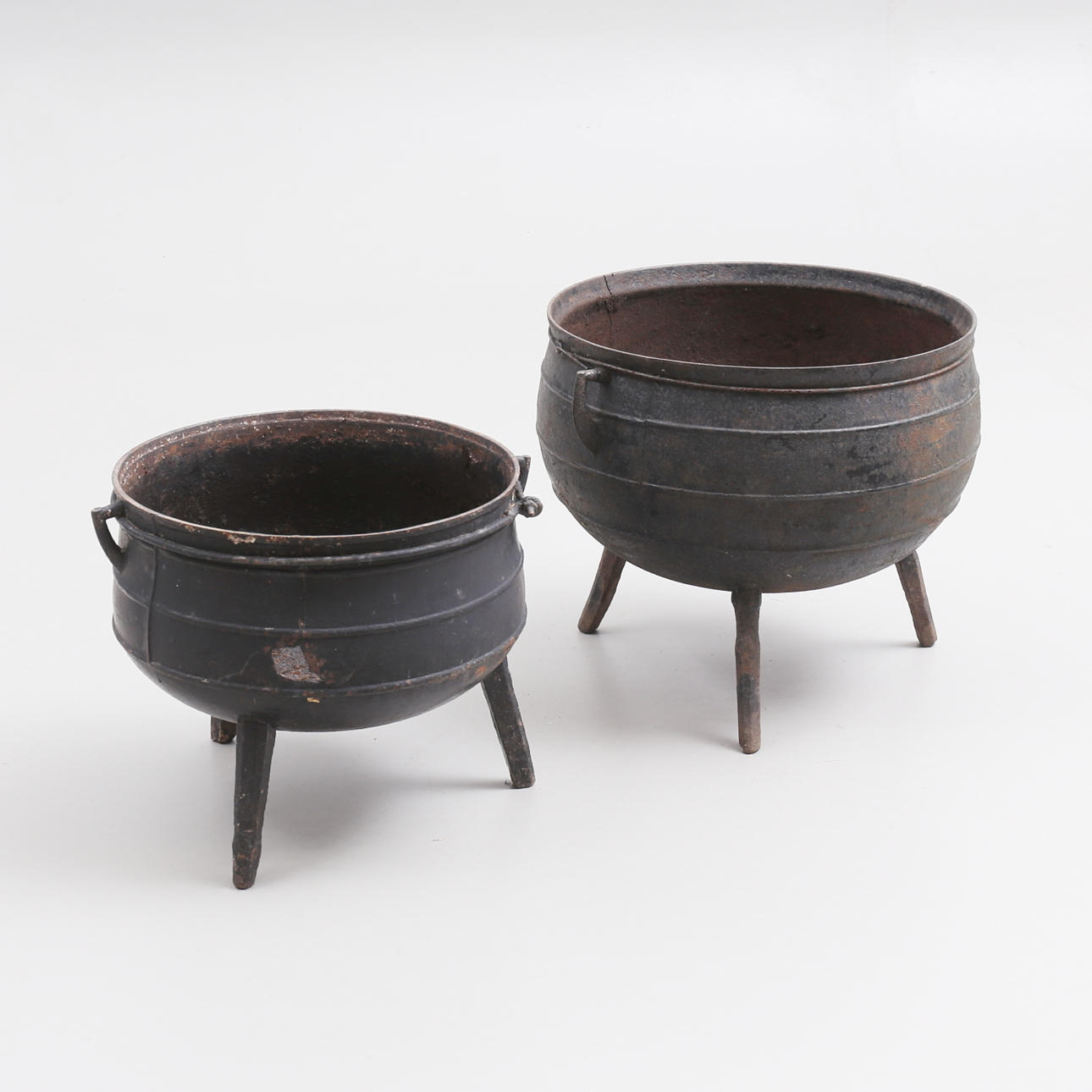 A set of 2 cast-iron cauldrons.