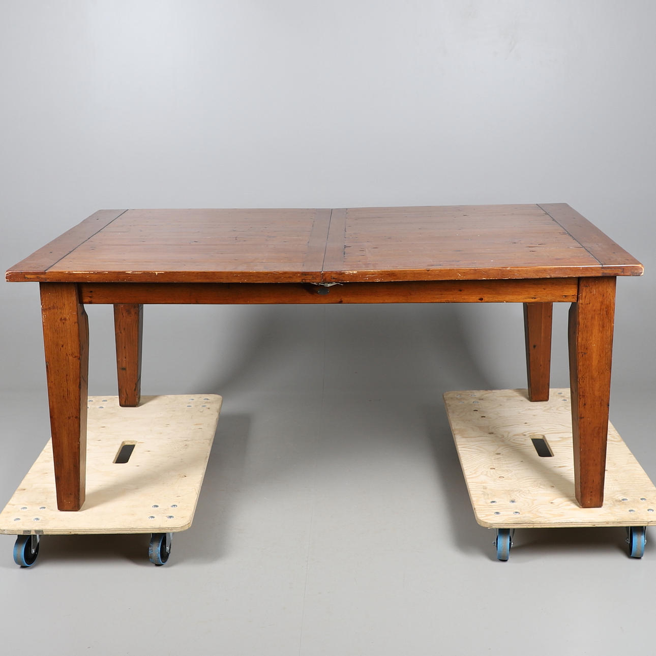 AN OAK EXTENDING DINING TABLE.