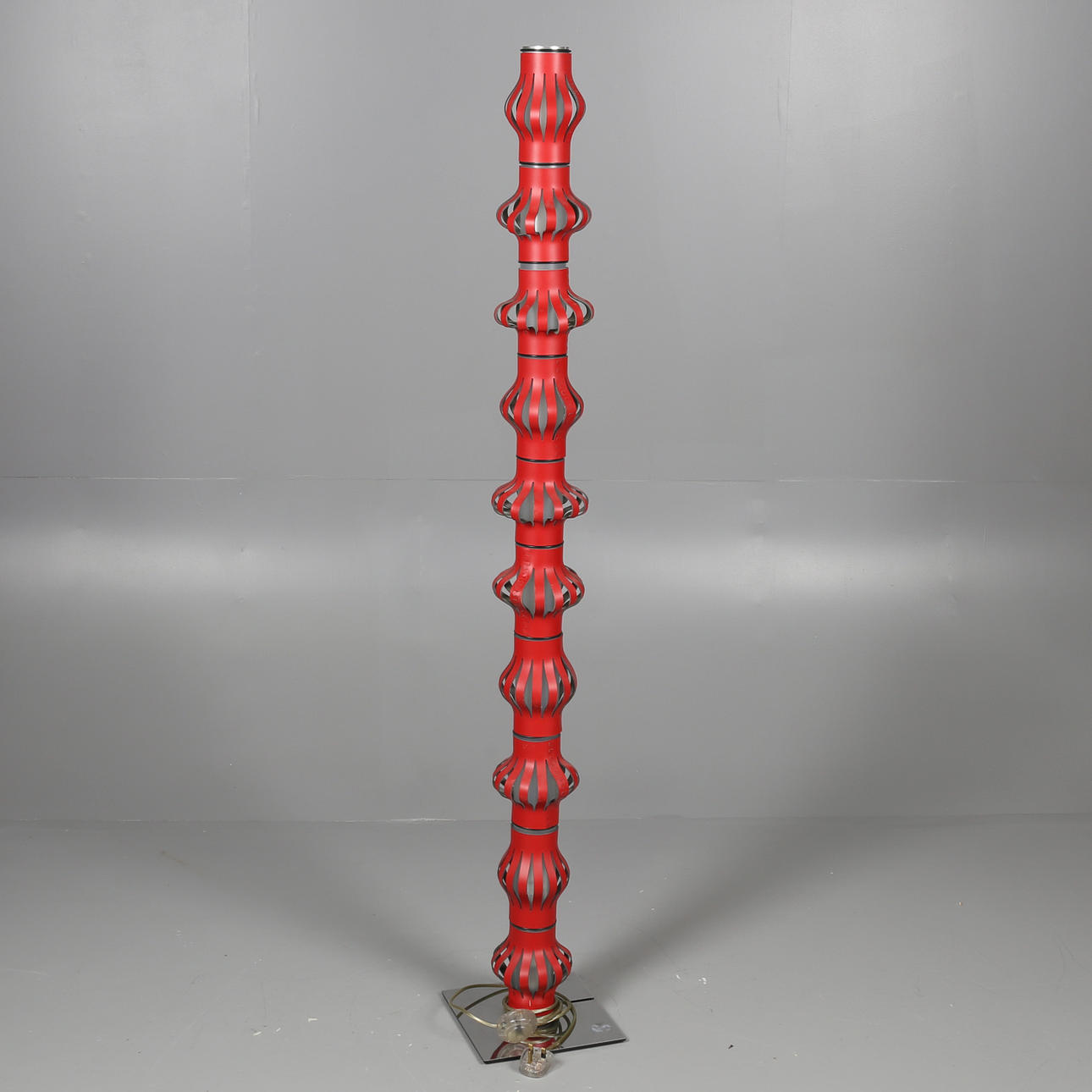 EN MODERN RÖD GOLVLAMPA.