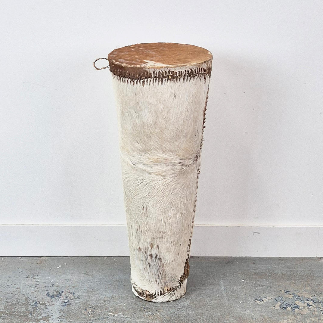 AN AFRICAN HIDE DRUM/SIDE TABLE.