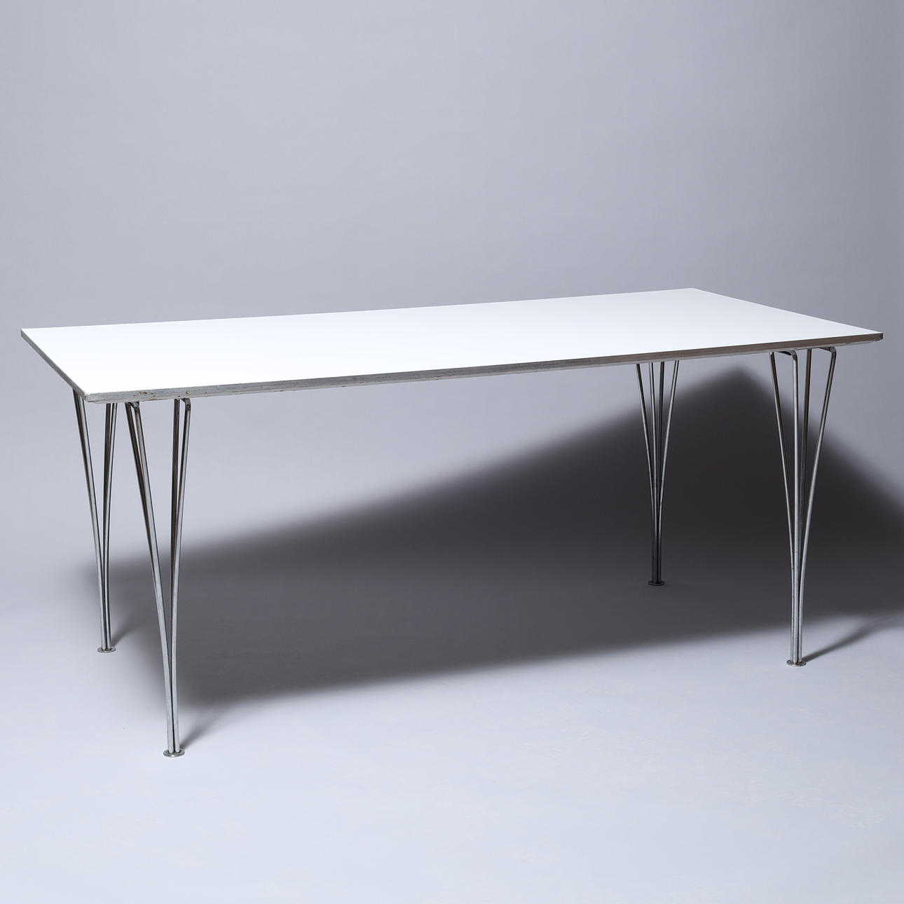 PIET HEIN. Rectangular dining table, white laminate top, chrome-plated metal clamps, Fritz Hansen, Denmark.