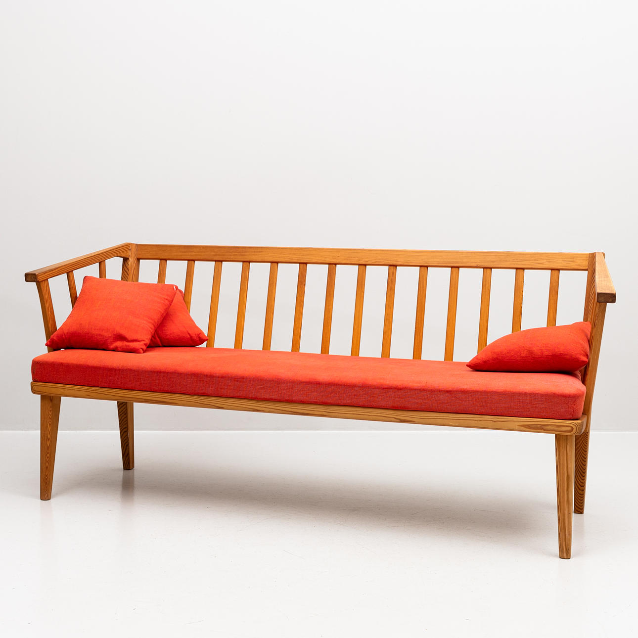 CARL MALMSTEN. Soffa "Visingsö" ek med röda dynor och kuddar.