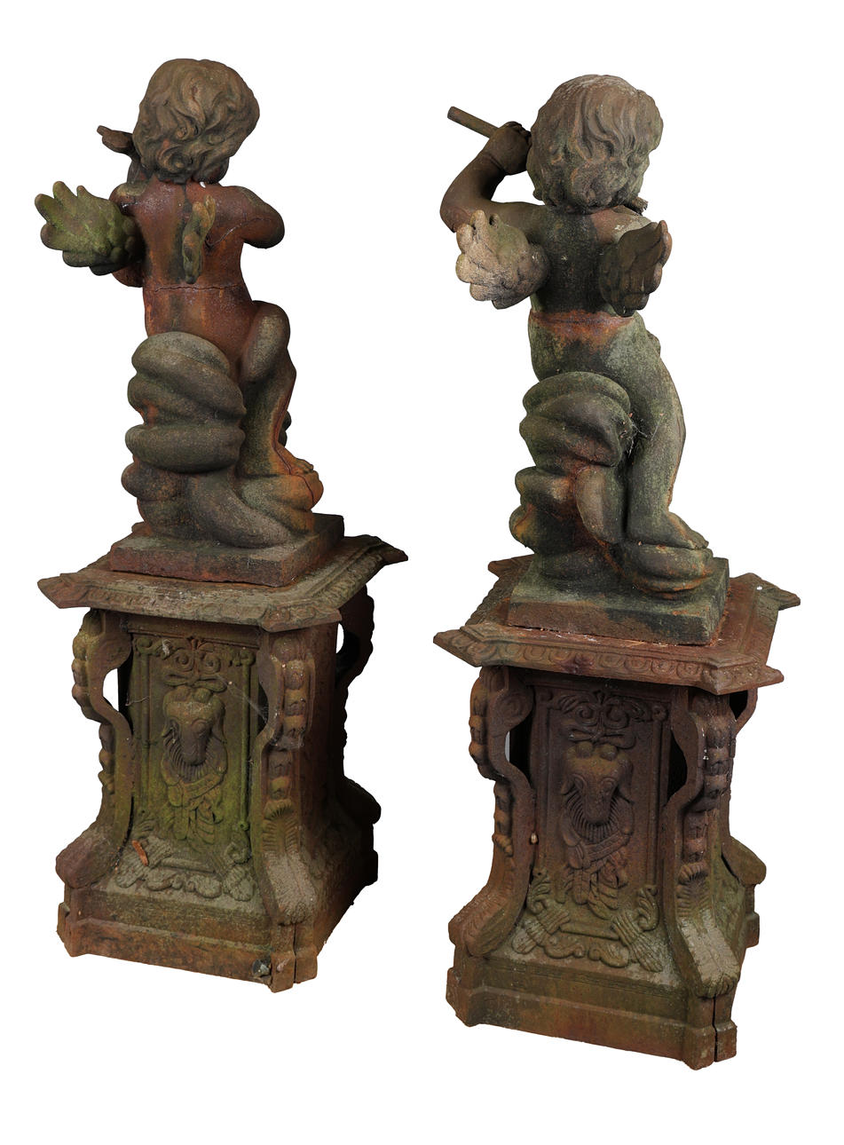 A LARGE PAIR OF CAST IRON CHERUBS ON PLINTHS (2). Garden ...