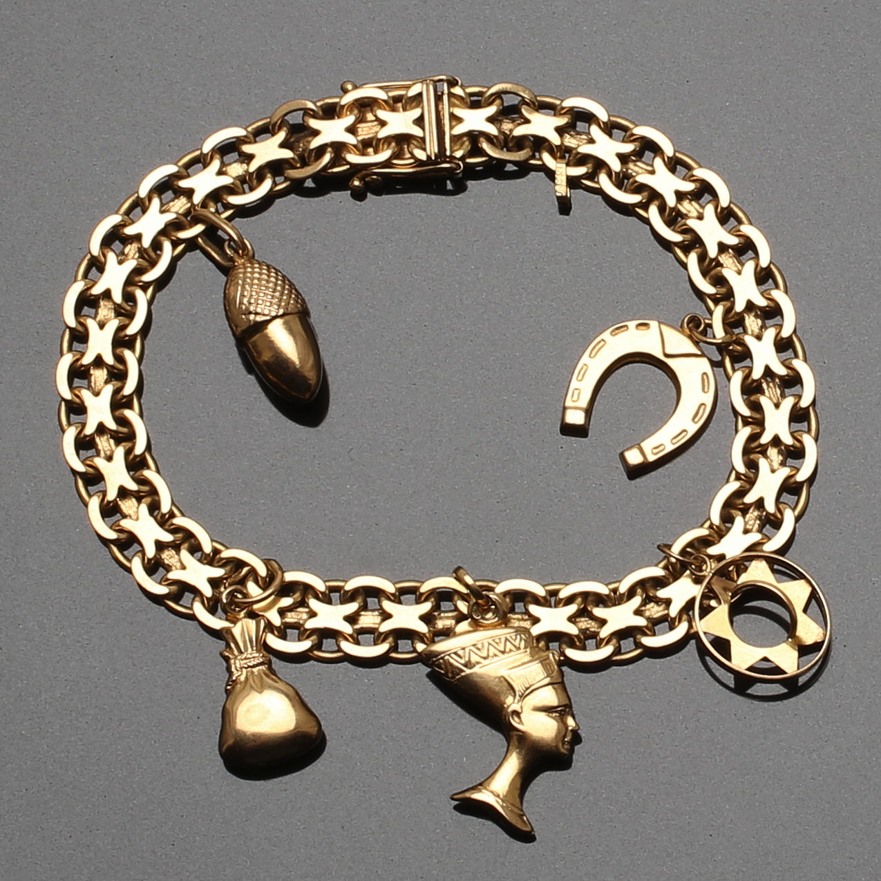 ARMLÄNK 18 K guld X-länk med 5 berlocker. 25 g.