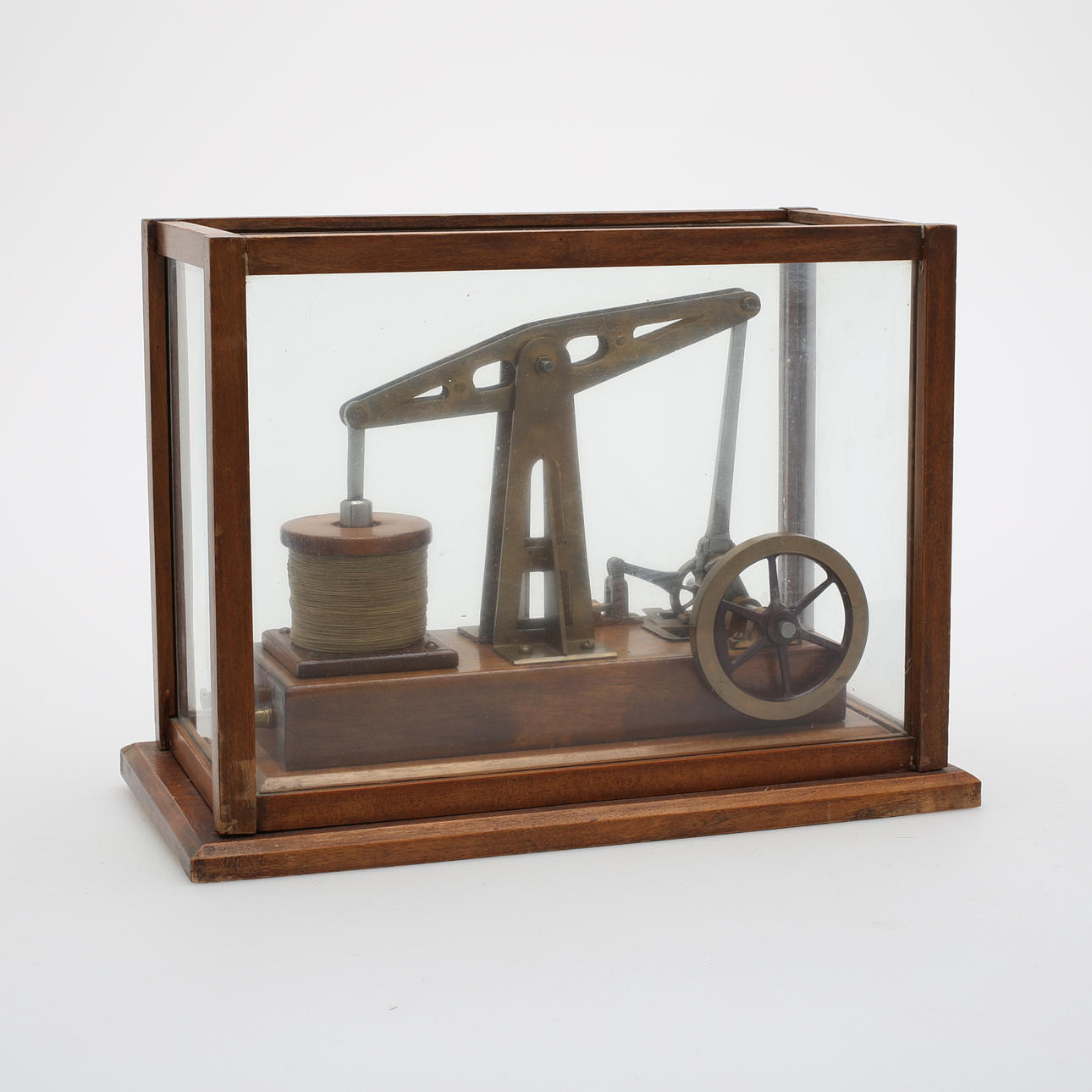 MASKINMODELL (kolvångmaskin?) i glasmonter, 1900-talets första hälft.