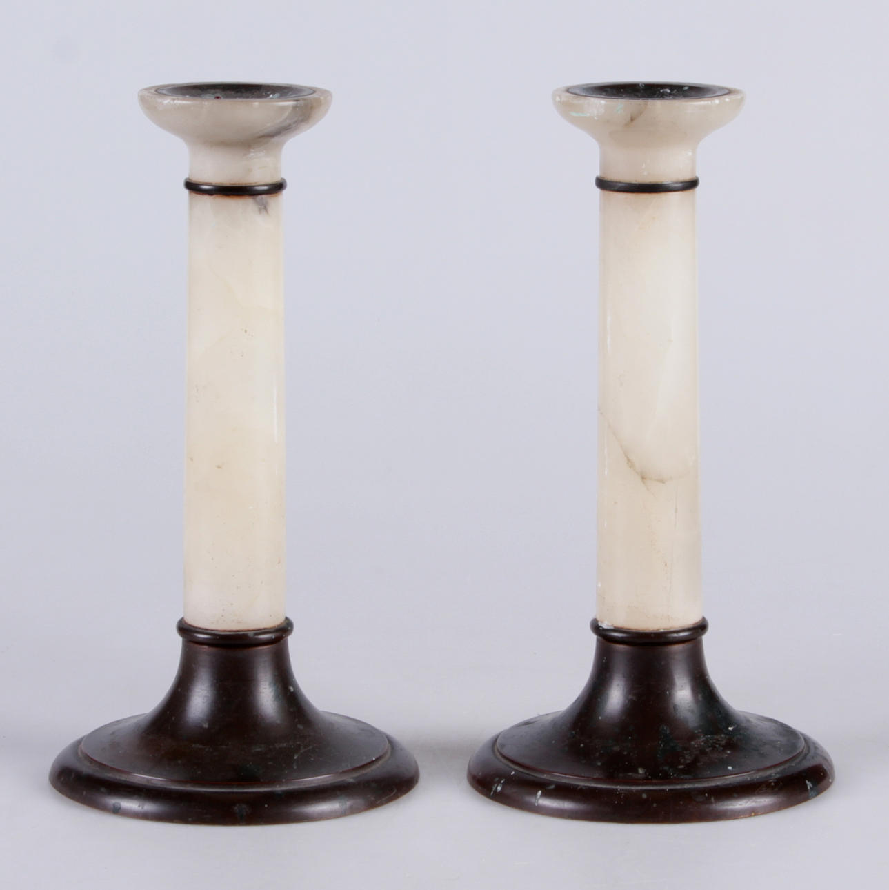 LJUSSTAKAR, ett par, alabaster samt patinerad metall, 1900-talets första hälft.