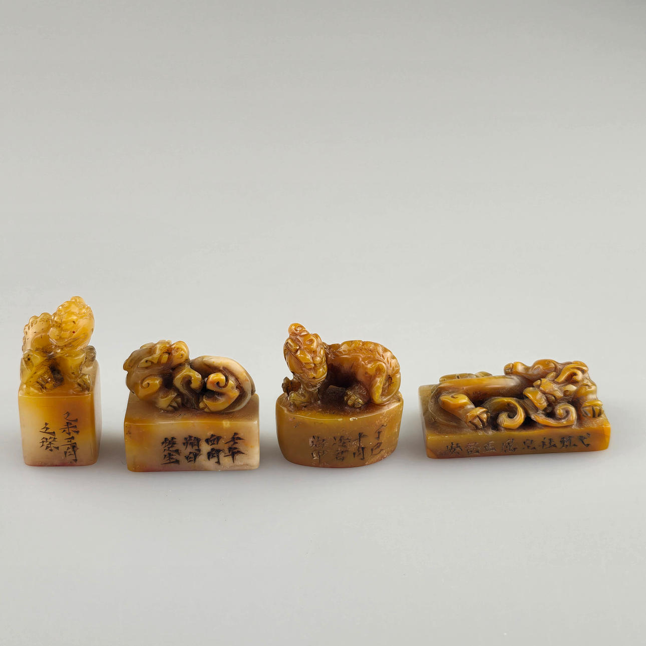 Four small STONE SEALS - China, caramel-colored stone types.