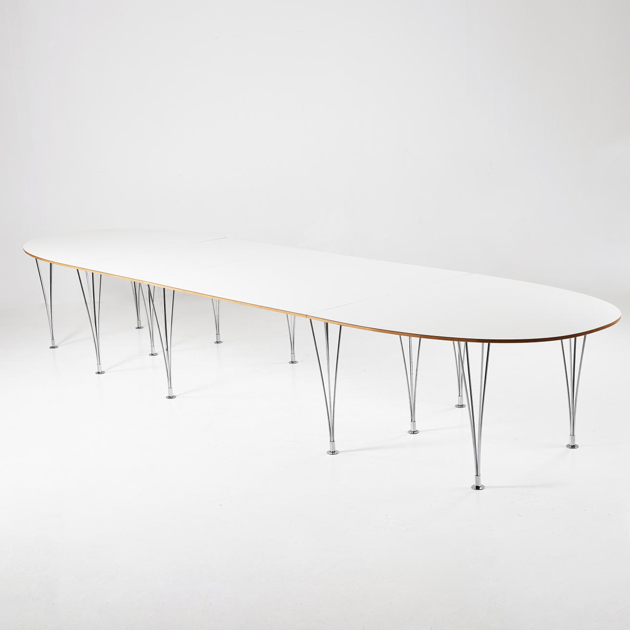 BRUNO MATHSSON. PIET HEIN & BRUNO MATHSSON, ein 4-teiliger Esstisch „Superellips“, Bruno Mathsson International, 2009. Weiße laminierte Scheibe auf verchromten Klemmbeinen.