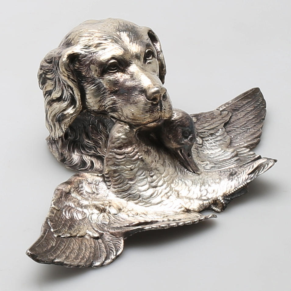 BLÄCKHORN, metall, hundhuvud med and, 1900-talets första hälft.