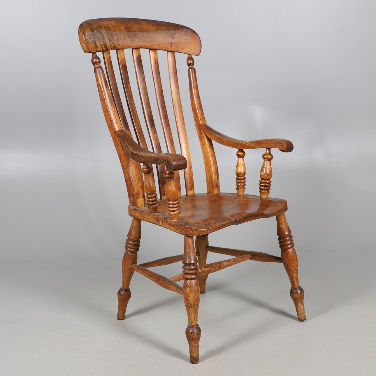 EN ELMSIDDENDE LANDSTOL MED HØJ PIND.