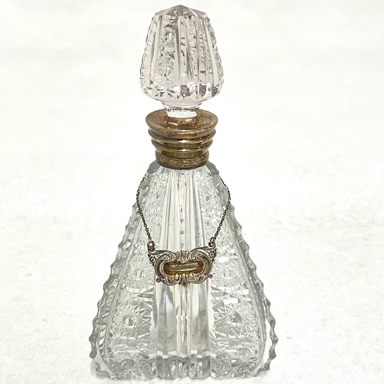 Schnapsflasche mit geschnitztem Glasschild und silbernem Kragen.