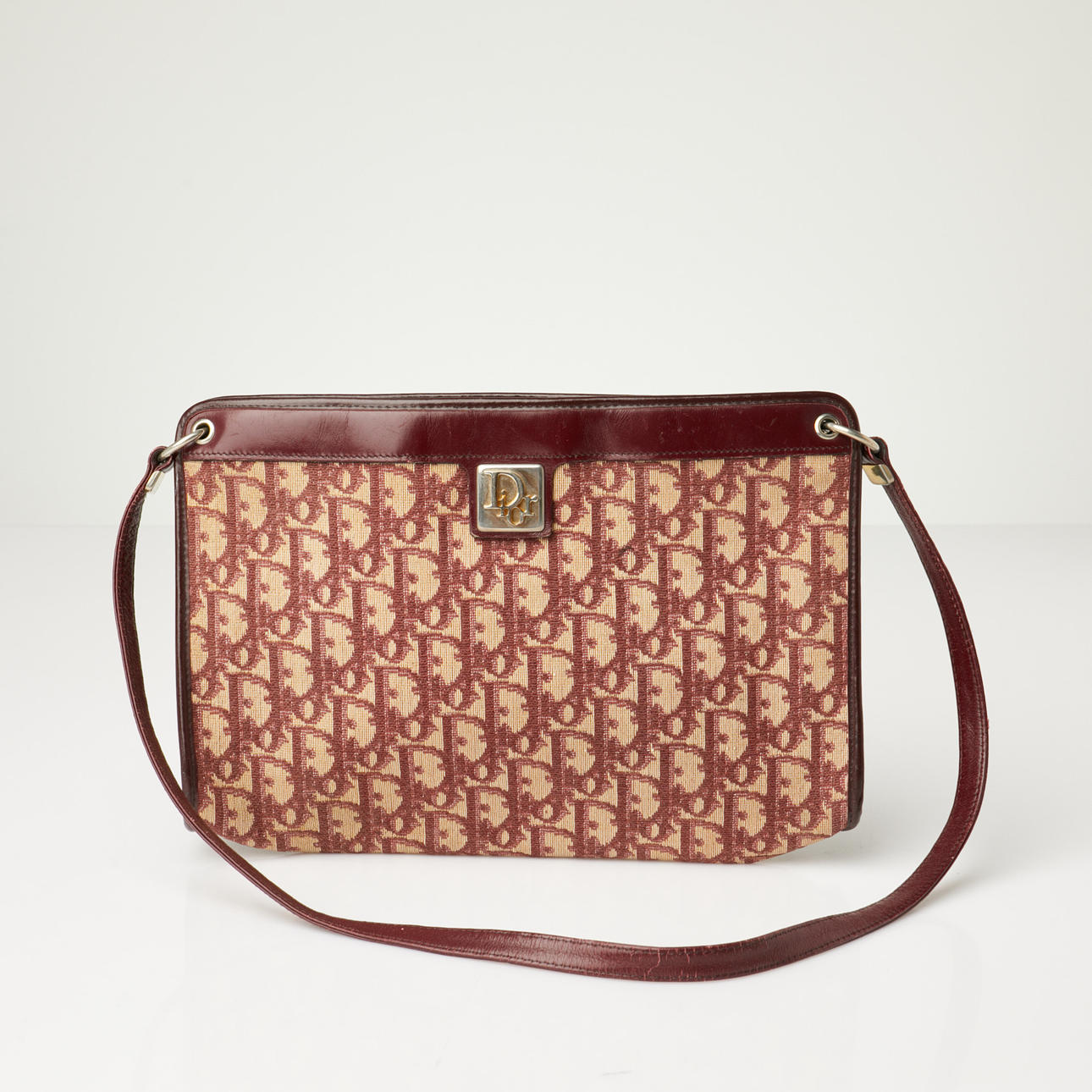 CHRISTIAN DIOR, Handtasche, monogrammierte Leinwand in beiger Farbe mit burgunderroten Details.
