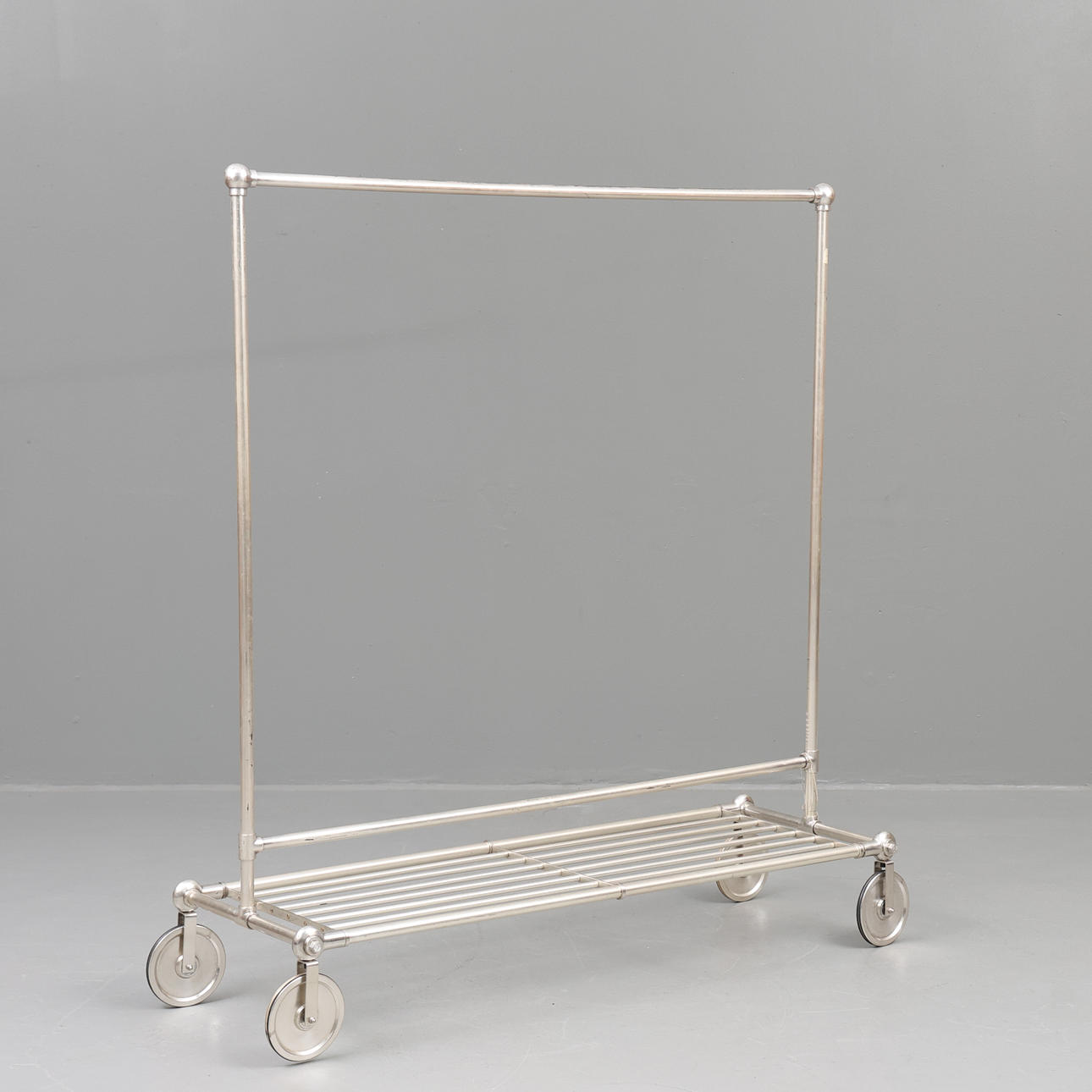 A metal clothes rack on wheels, 20th century.