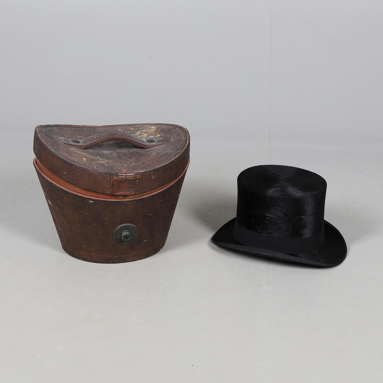 EN TOPPHATT I SILKE I LÄDERFODRAL.