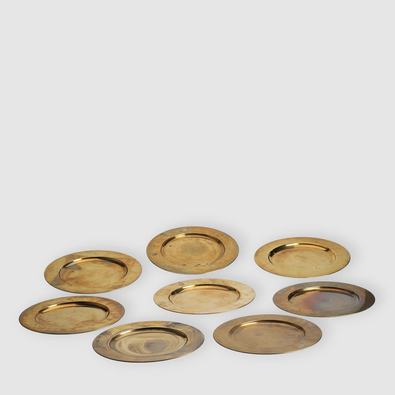 Otte dækketallerkner af messing (8).