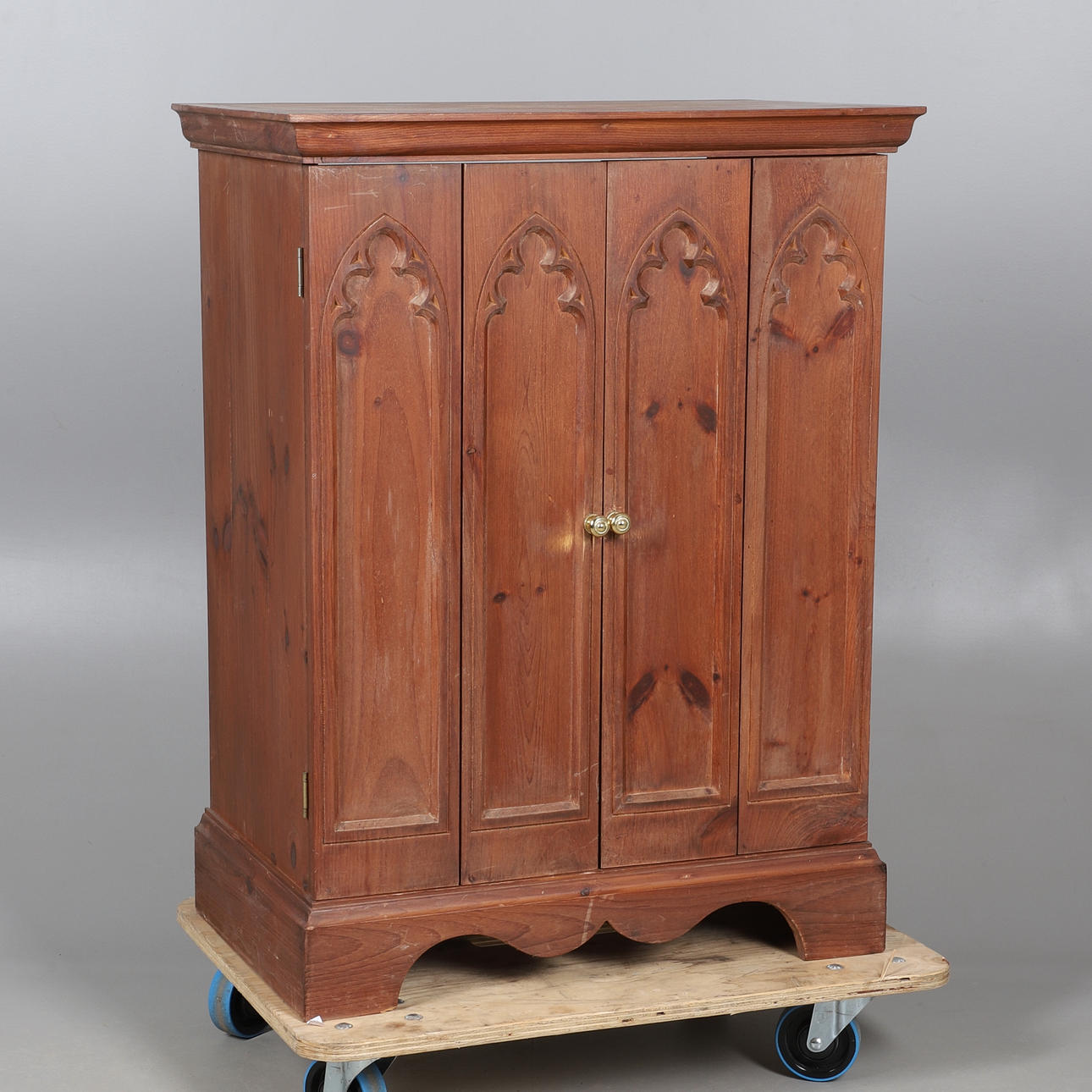 A PINE TWO DOOR CUPBOARD WITH GOTHIC PANELS.