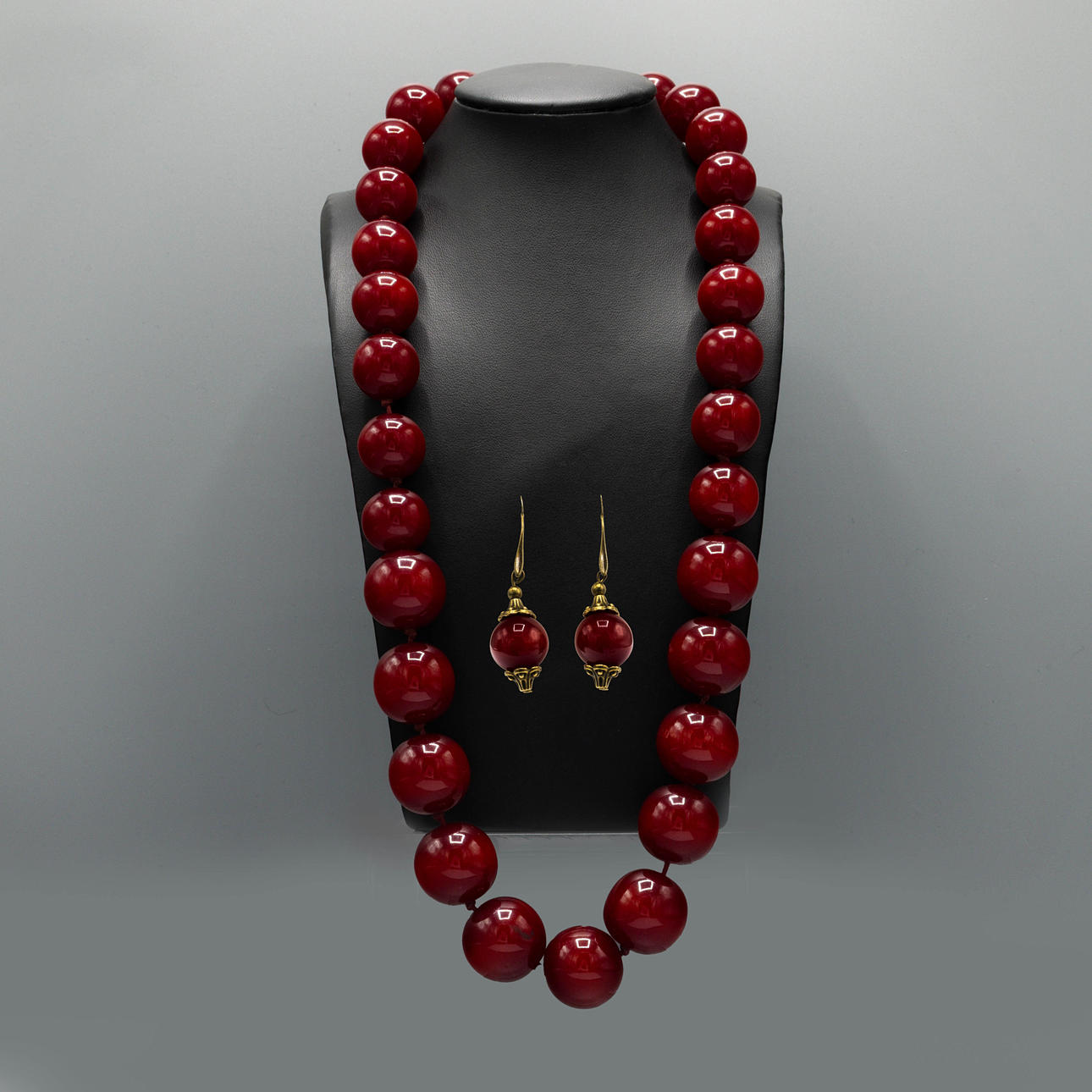 A CHERRY AMBER TYPE BEAD NECKLACE AND EARRINGS SET.