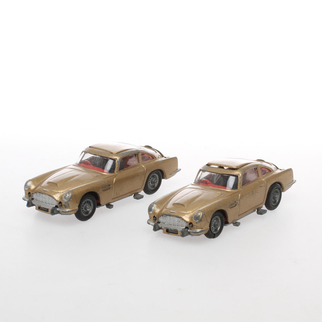 CORGI 2 stycken guldfärgade ASTON MARTIN 007 James Bond med förare och passagerare.
