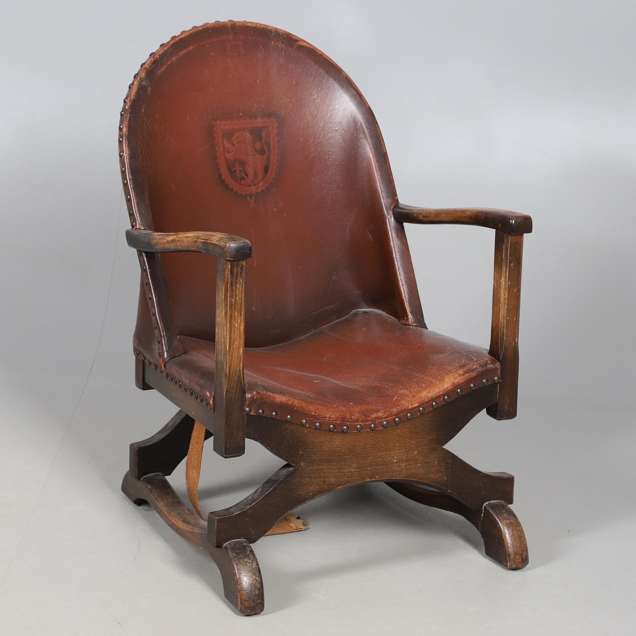 A SPANISH STAINED BEECH & LEATHER ARMCHAIR.