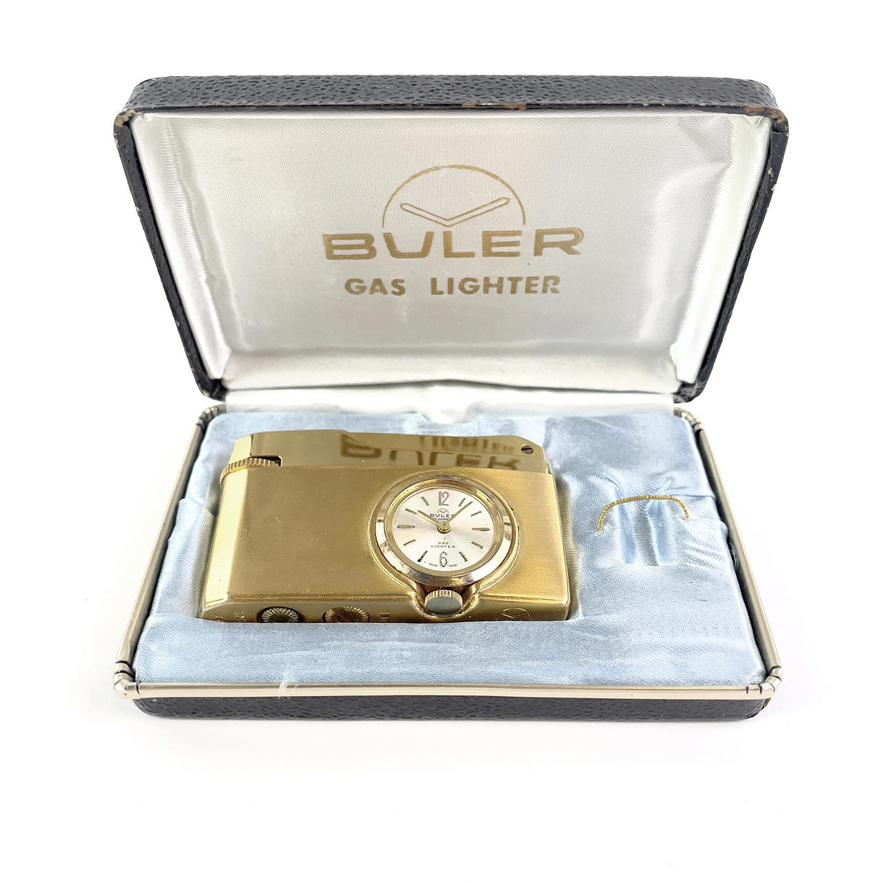 PROTUBERANCIAS. Mechero con reloj integrado, dorado, en su embalaje original, Suiza.