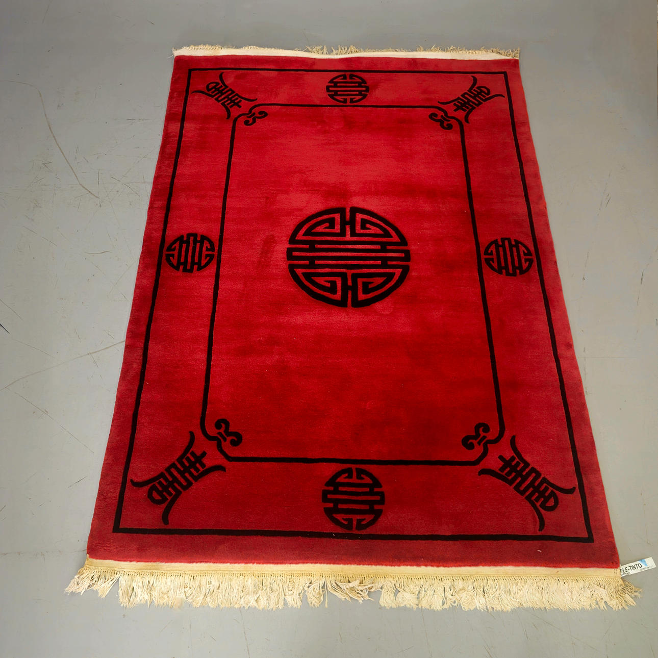 ORIENTAL WOOL CARPET IN RED AND BLACK TONES.