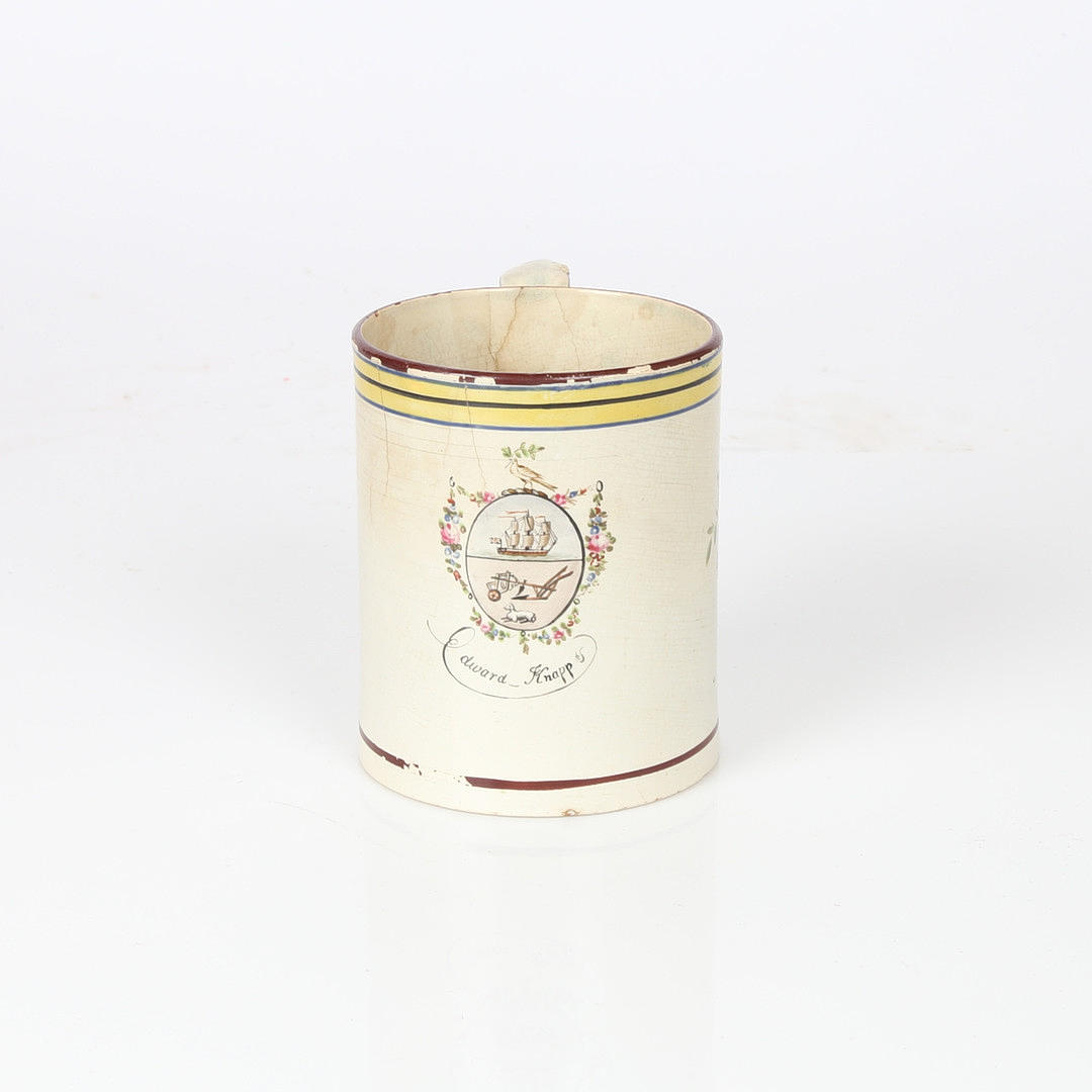 AN 18TH CENTURY CREAMWARE MUG.