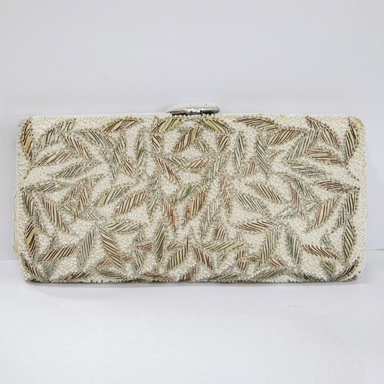 MAGDA. Rhinestone clutch with leaf motif in soft tones.