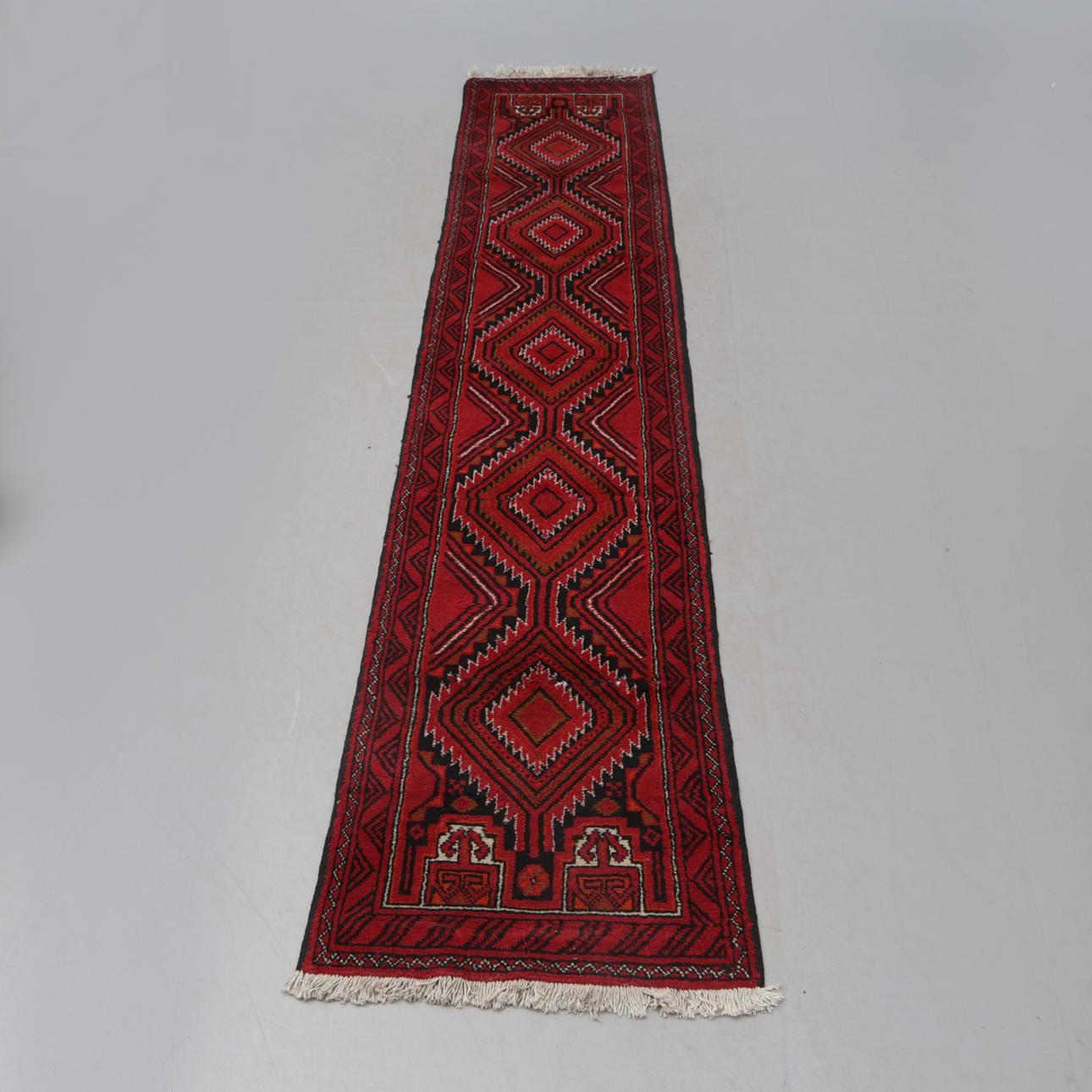 A CARPET, red, Persia. 292x60.