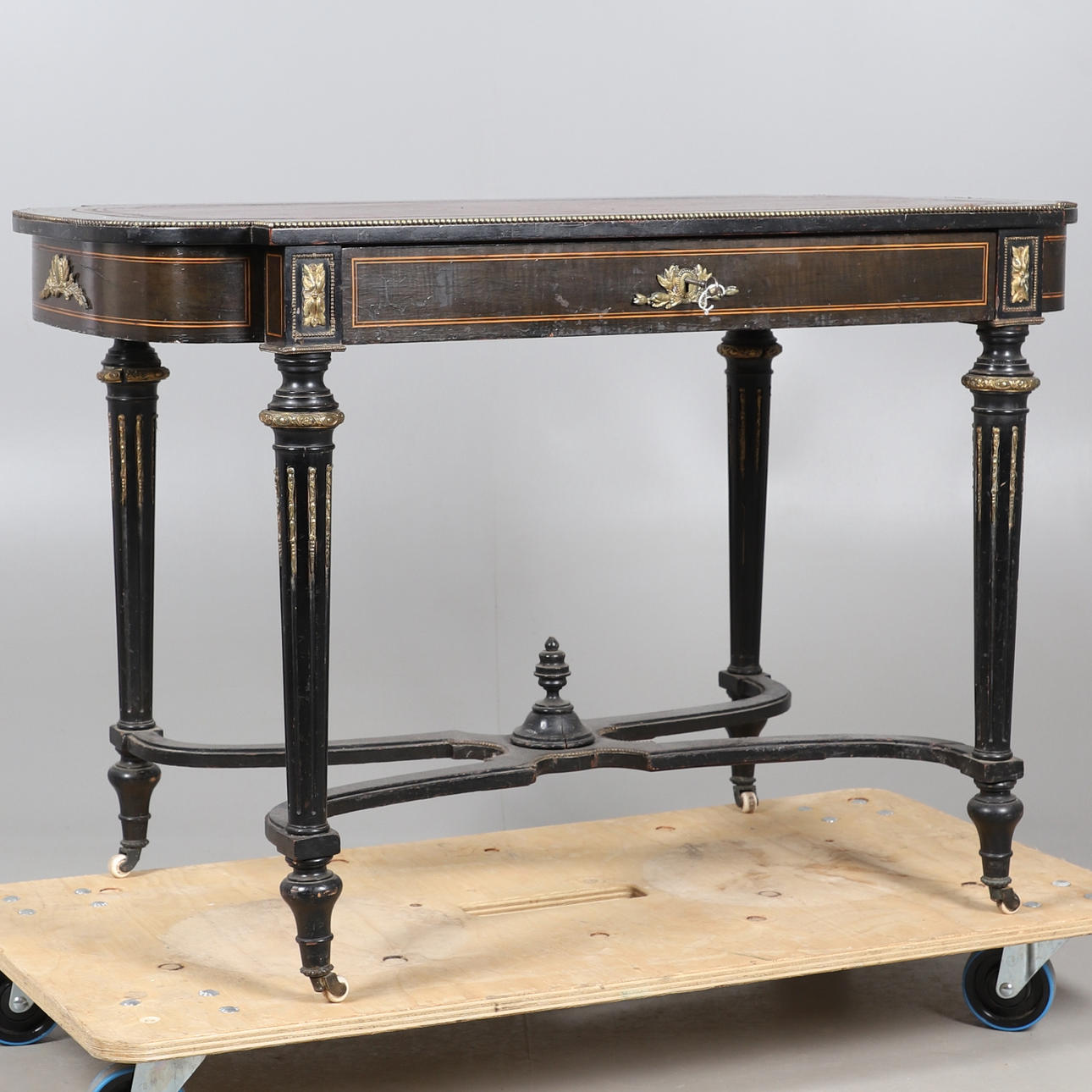 A LEATHER TOPPED EBONISED SIDE TABLE.