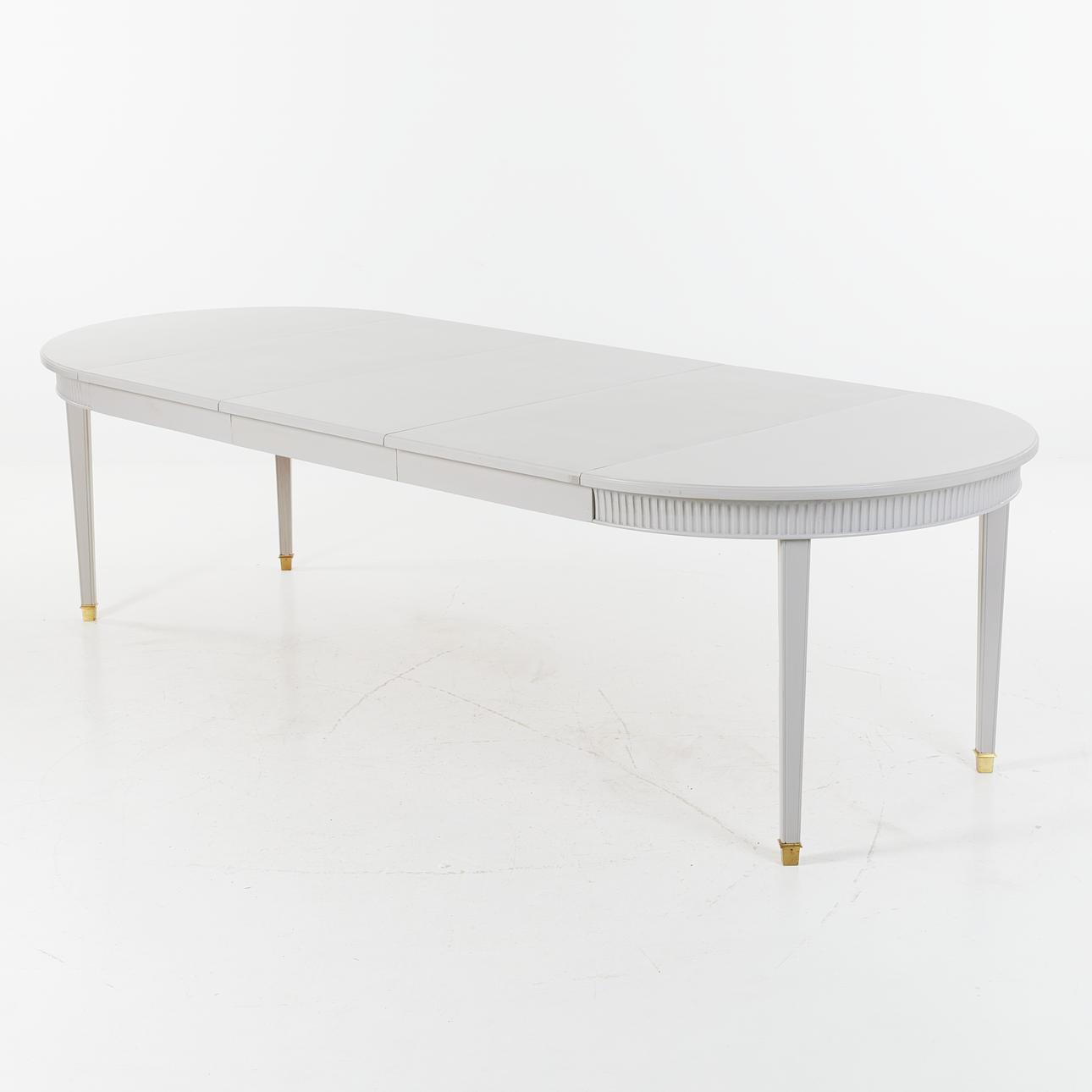 A Gustavian style dining table, 20th century, painted, brass leg end.