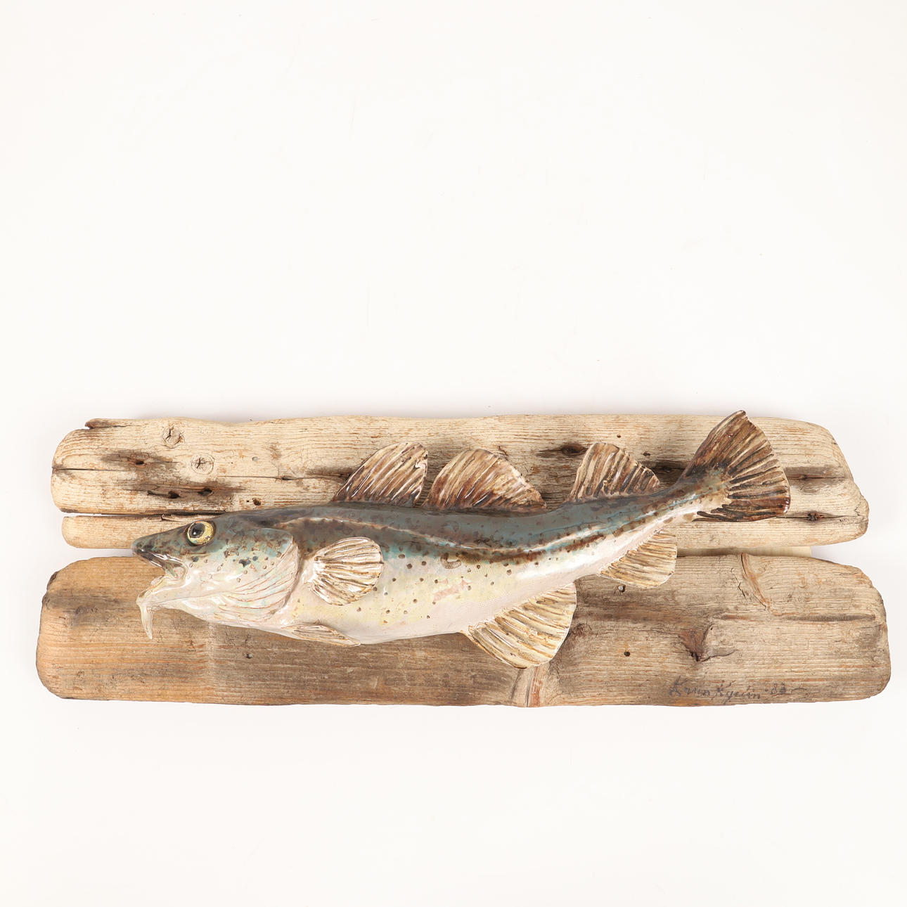 KARIN KYRLIN. Sculpture, cod, ceramic mounted on driftwood, signed and dated 1983.