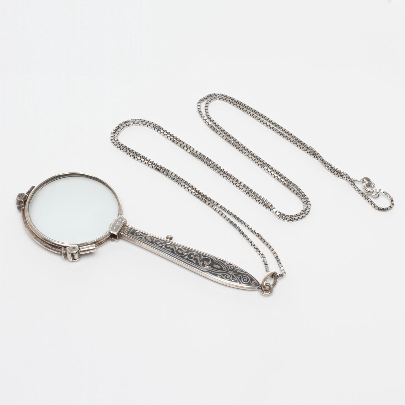 LORNJETT med kedja, silver, 1900-talets första hälft.