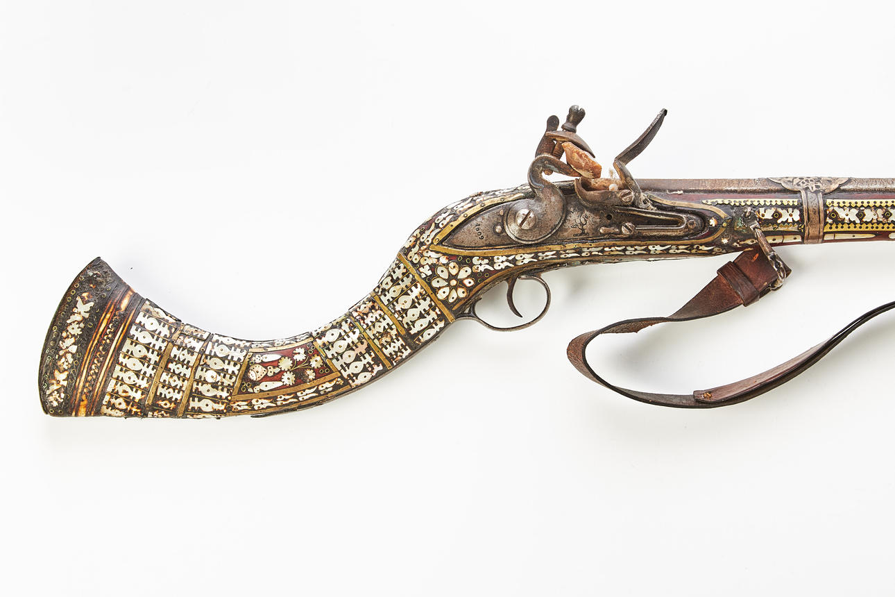 A flintlock JEZAIL, Afghanistan, circa mid 19th century, log with abundant inlays in mother-of-pearl and brass, browned barrel with fittings in low grade silver.