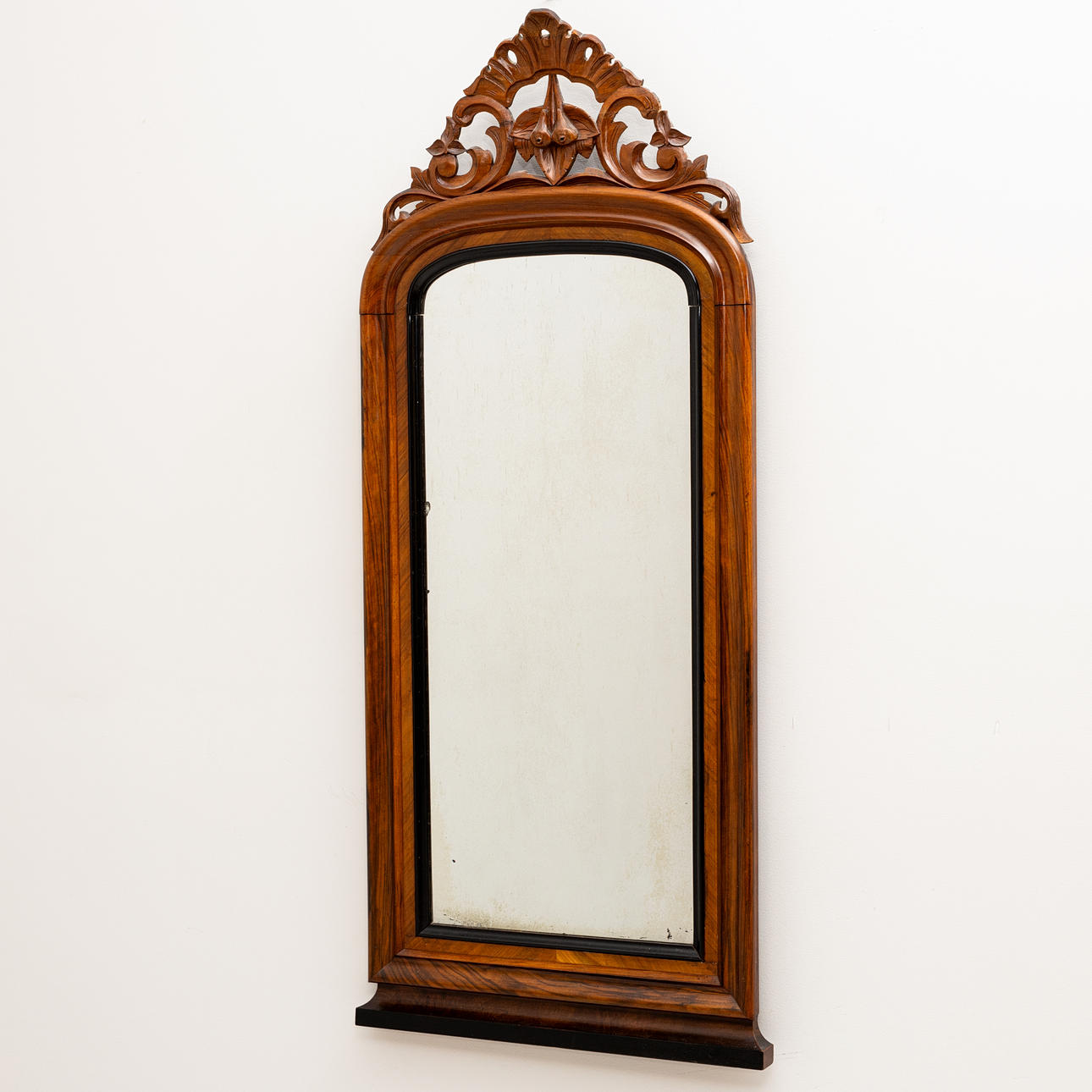 A walnut mirror with blackened details, Neo-Rococo, late 19th century.