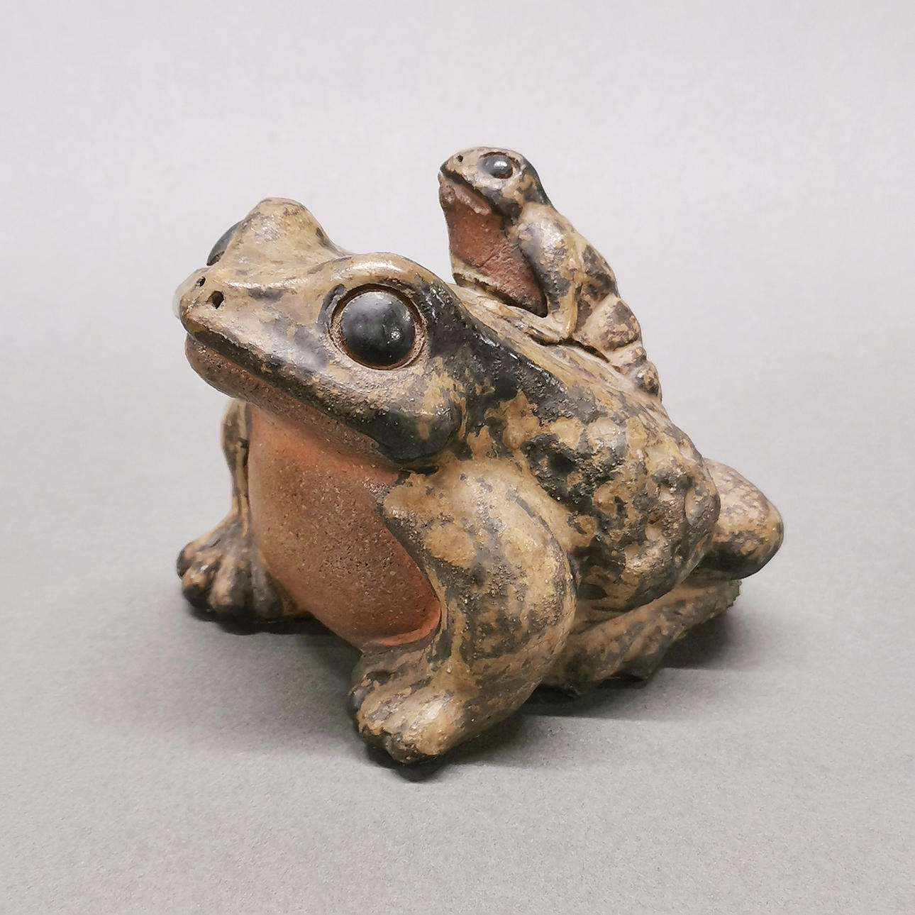 GLASERAD ASIATISK MODELL AV TVÅ GRODOR.