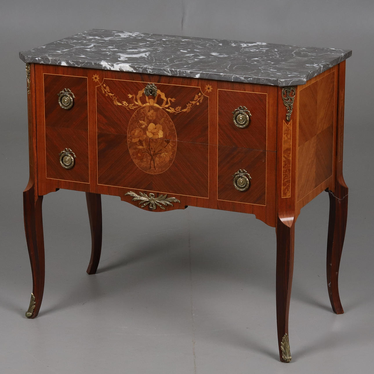 A Gustavian style intarsia chest of drawers with stone top, 20th century.