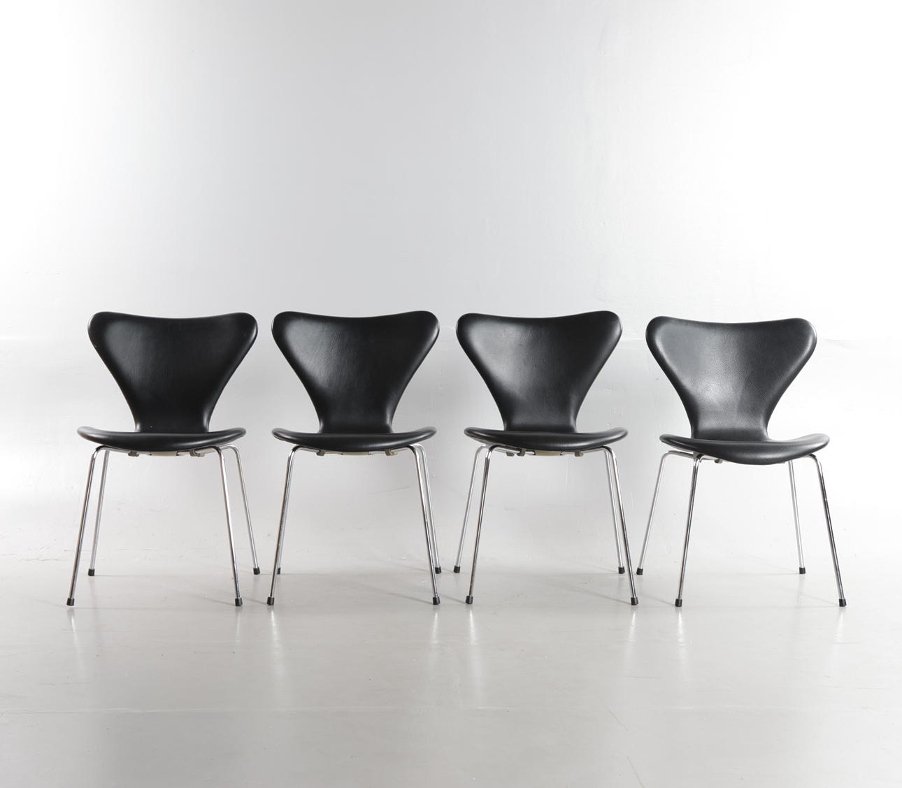 ARNE JACOBSEN. Set of four 'Syveren' chairs, upholstered in black ...